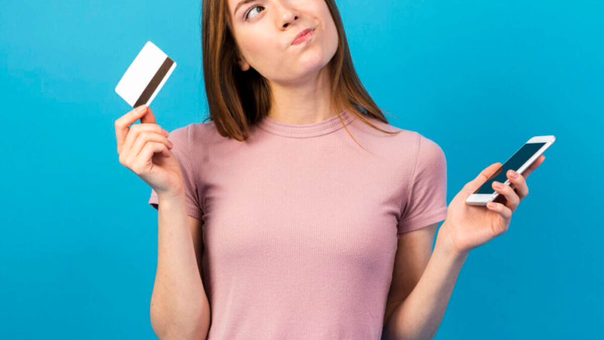 mulher decidindo qual é o melhor entre as opções de cartões sem crédito sem anuidade